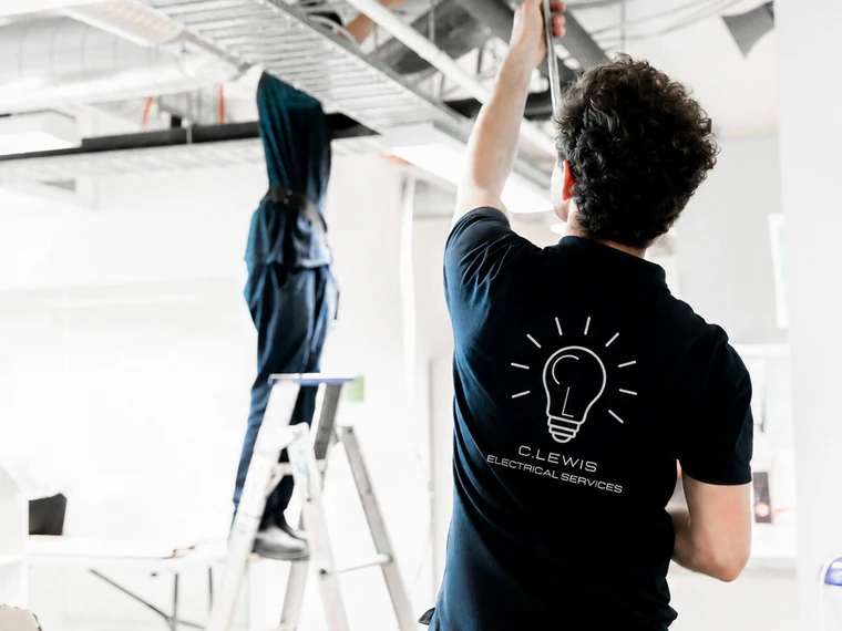 C.Lewis electrician installing ceiling lighting in a commercial premises in southern Sydney