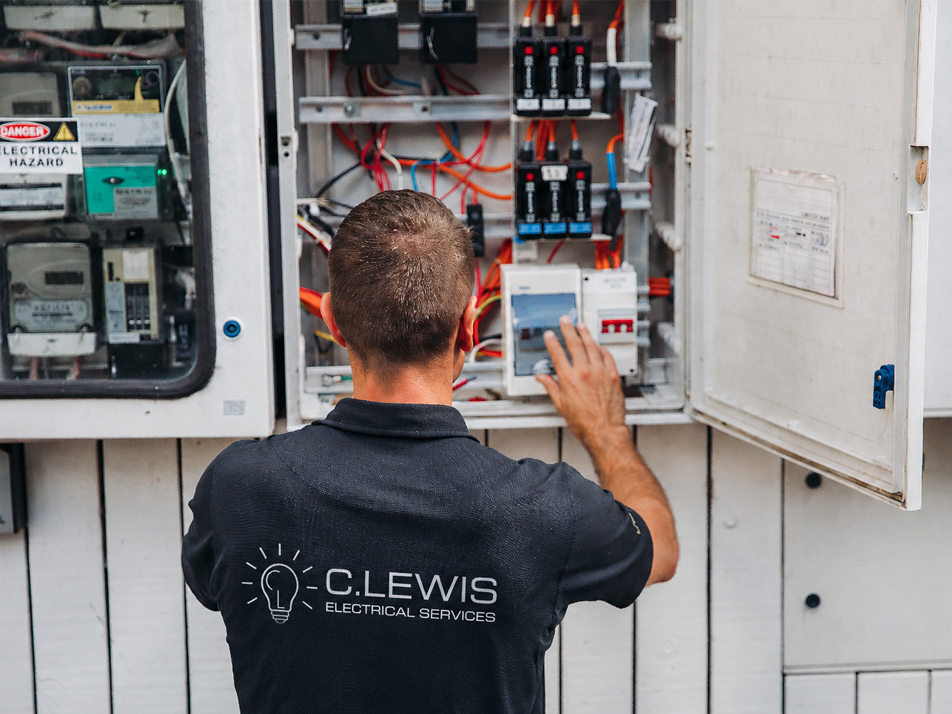 C.Lewis electrician testing circuit breakers inside an open switchboard at a Sutherland Shire property